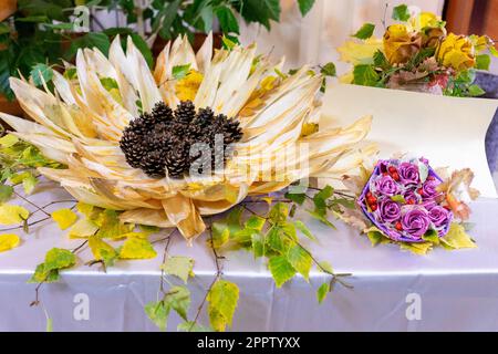 Dekorative Sonnenblumen von Hand aus Maiskegeln und -Blättern Stockfoto