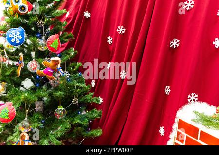 Der Weihnachtsbaum ist mit Girlanden und verschiedenen Spielzeugen dekoriert Stockfoto