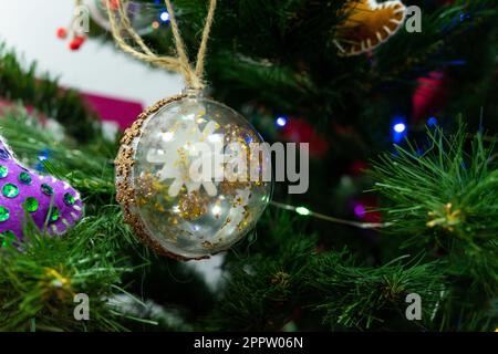 Den Weihnachtsbaum mit Glasspielzeug dekorieren Stockfoto