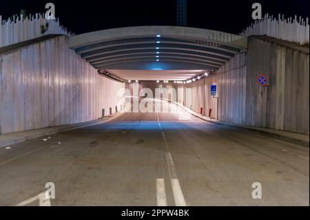 Straße, Autobahn, Tunnel, Unterführung beleuchtet durch künstliche Lichter bei Nacht. Stockfoto