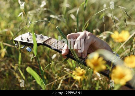 Männerhände spielen Akustikgitarre, Nahaufnahme. Akustikgitarren spielen. Musikkonzept. Akustische Gitarren. Männlicher Musiker, der Gitarre spielt, Musikinstrume Stockfoto
