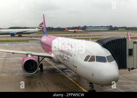 Wizz Air Airbus A320 Flugzeug am Südterminal, London Gatwick Flughafen, England, Großbritannien, mit Blick durch Glasfenster mit einigen Reflexionen Stockfoto