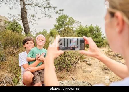 Mutter fotografiert ihre glücklichen Söhne in der Natur. Stockfoto