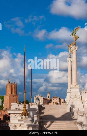 Altar der Nation oder „Vittoriano“-Denkmal im Zentrum von Rom, mit mittelalterlichem Milita-Turm und alter Kirche im Hintergrund Stockfoto