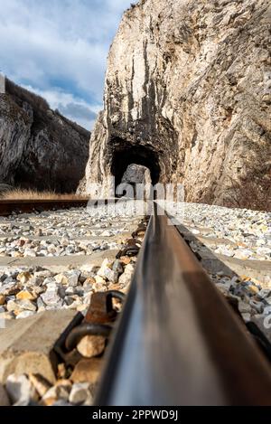 Alte Eisenbahn durch kurze Tunnel in malerischer ländlicher Landschaft Stockfoto