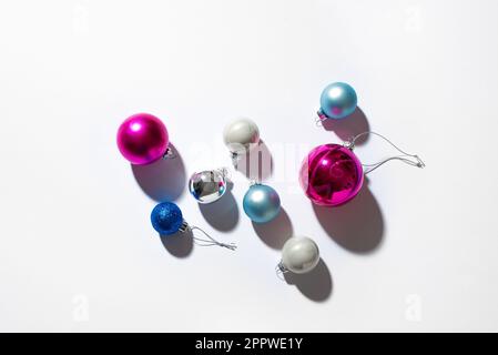 Weihnachtsbaumkugeln, festlich-trendige Komposition mit hartem Licht und Schatten auf weißem Hintergrund. Weihnachten, Neujahr, minimaler kreativer Conce Stockfoto