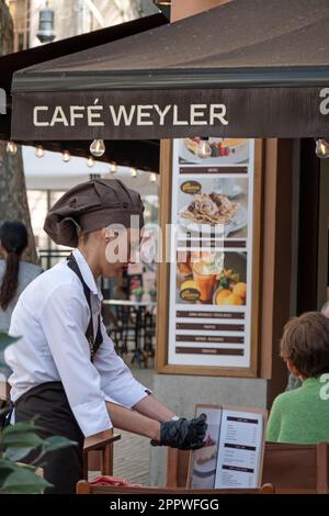 Mallorca, Spanien -30, März 2023. Eine Kellnerin in Uniform serviert einen Tisch im Café Sa Gelateria de Mallorca Stockfoto