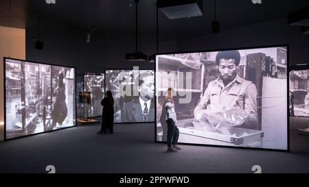 London, Großbritannien. 25. April 2023 Ein Angestellter mit "noch einmal ..." (Statues Never die)“, 2022 von Isaac Julien bei der Vorschau von „Isaac Julien: What Freedom is to me“, einer Retrospektive Ausstellung in Tate Britain zur Feier des einflussreichen britischen Künstlers und Filmemachers Sir Isaac Julien. Vom 26. April bis zum 20. August 2023 werden eine Auswahl der bahnbrechenden frühen Filme von Julien, Beispiele für fesselnde Videos mit drei Bildschirmen für die Galerie und mehrere der skulpturellen Installationen mit mehreren Bildschirmen, für die er heute bekannt ist, gezeigt. Kredit: Stephen Chung / Alamy Live News Stockfoto