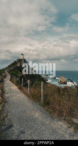 Atemberaubende Aussicht auf den Nugget Point Lighthouse und seine felsige Kulisse, South Island, Neuseeland Stockfoto