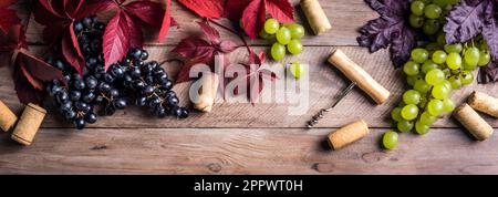 Weinkorken, Korkenzieher und Trauben auf altem Holzhintergrund, Banner. Konzept für Weinfestival, Weingut oder Weinprobe. Stockfoto