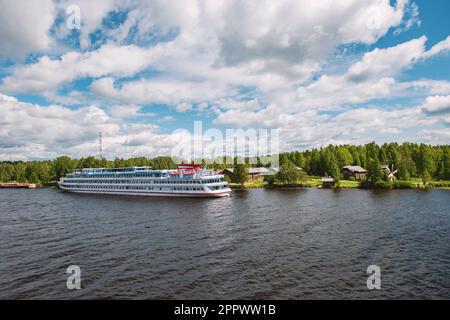 MANDROGI, RUSSLAND - 8. JUNI 2015: Karelien, alte Holzhäuser am Ufer des Flusses Svir. Restauriertes altes Dorf, Liegeplatz des Touristenschiffs Stockfoto