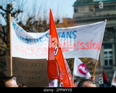 Strasborg, Frankreich - 29. März 2023: Eine Gruppe erwachsener Demonstranten versammelt sich vor einem großen architektonischen Gebäude und hält Flaggen und Plakate mit Text Prot Stockfoto