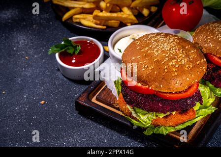 Gesunde vegetarische Burger mit Gemüsekoteletts. Hausgemachte Rote-Beete- und Karotten-Burger mit frischem Gemüse, veganer Mayo-Tomatensoße, Vollkornbrötchen, Stockfoto