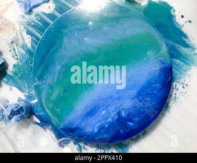 Abstraktes ungewöhnliches Gemälde, das den Ozean mit einer Epoxid-Maltechnik darstellt, um Kunstwerke zu erschaffen. Bild auf einem farbigen blauen Hintergrund mit Blasen. Stockfoto