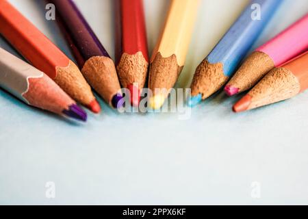 Wunderschöne helle Holzspitzstifte zum Zeichnen. Flacher Platz zum Ablegen und Kopieren auf blauem Hintergrund. Stockfoto