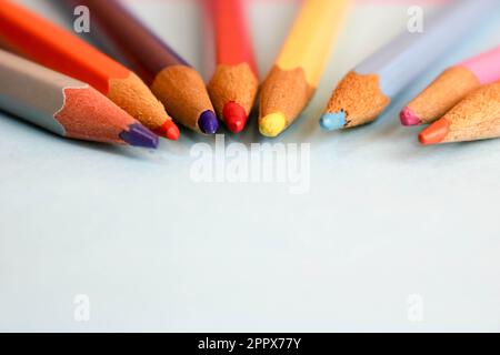 Wunderschöne helle Holzspitzstifte zum Zeichnen. Flacher Platz zum Ablegen und Kopieren auf blauem Hintergrund. Stockfoto