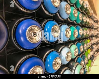 Selbstlackierend, Graffiti – mehrfarbige Spraydosen mit Farbe auf dem Regal für die Autoreparatur. Stockfoto