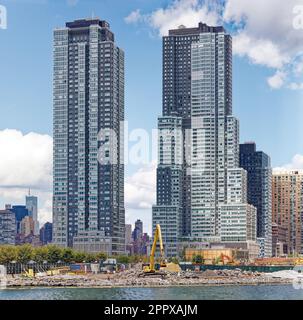 Der zweistöckige Hunter's Point South-Komplex mit Blick auf den East River. Im Vordergrund wird ein neues Projekt mit drei Türmen gebaut. Stockfoto