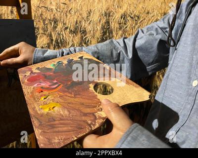 Das Ölgemälde des Künstlers Pinsel Mix auf Palette hält in seiner Handnaht. Stockfoto