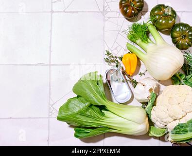 Draufsicht mit frischem grünen Gemüse auf gefliestem Hintergrund bei Sonnenlicht Stockfoto