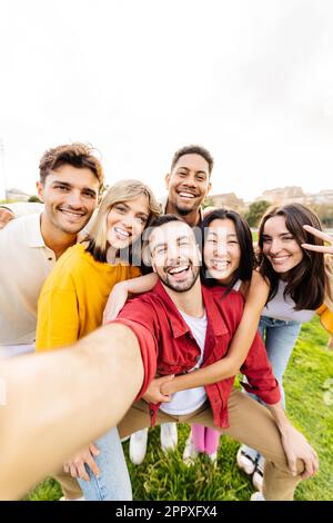 Vertikales Gruppenporträt von multiethnischen jungen Freunden, die Selfie mit dem Handy machen Stockfoto