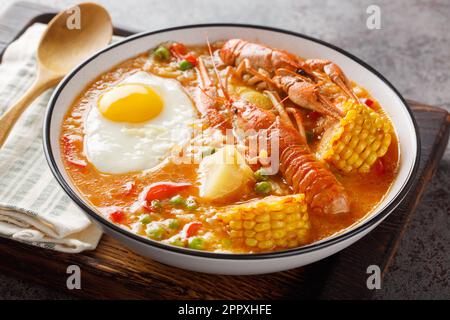 Dicke Suppe mit Flusskrebsen, Tomaten, Mais, Pfeffer, Kartoffeln, Grünes Erbsen und Ei in einer Schüssel auf dem Tisch. Horizontal Stockfoto