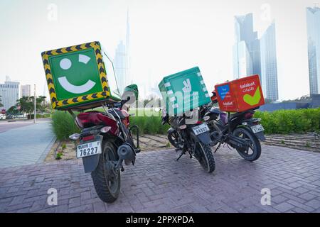 Motorrad-Food-Lieferung auf dem Parkplatz. Dubai, Vereinigte Arabische Emirate - April 2023 Stockfoto