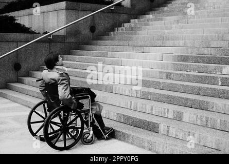 Schwarz-Weiß-Bild einer Führungskraft in einem Rollstuhl, die sich einer sehr schwierigen Situation gegenübersieht Stockfoto