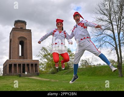 25. April 2023, Brandenburg, Burg: Julia Schmidt und Jakob Schäfer, Darsteller des sorbischen Nationalensemblums aus Bautzen (Sachsen), verkleidet als Lutkis (Sorbisch für Leutchen) vor dem Bismarkturm am Rande der Pressekonferenz für die Vorschau auf den Spreewald Sagennacht 14. Diese Woche beginnen die Proben für den Spreewald Sagennacht 14. im sorbischen Nationalensemble. Am Pfingstwochenende vom 27. Bis 29. Mai können die Zuschauer ein weiteres aufregendes Abenteuer im Reich des Wenden King zusammen mit den Lutki Jolka und Jorko auf dem Burger Schlossberg erleben. Stockfoto