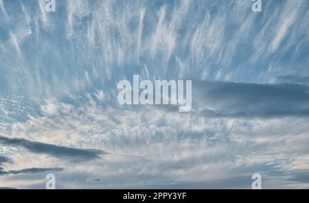 Himmel mit Zirrus- und stratuswolken, kontrastreicher Hintergrund der Natur, Wetterwechsel, Sonnenuntergang Stockfoto