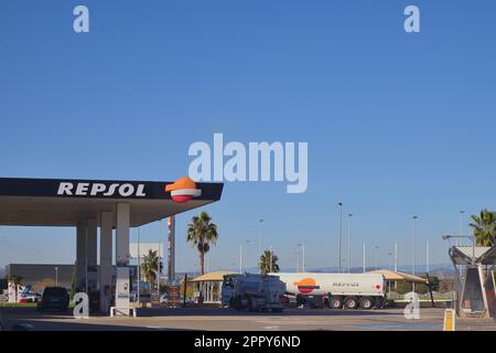 Allgemeine Aufnahme einer Tankstelle, die dem multinationalen Unternehmen Repsol gehört, einem Treibstofflieferanten, wo einige geparkte Autos sind. Bild mit Kopierbereich. Stockfoto