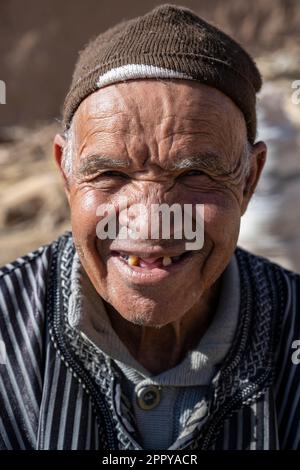 Berber, alter Mann in Djellaba, der Gemüse pflückt. Stockfoto