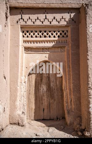 Holztür in einem lehmziegelhaus in der alten Medina von Tinghir, dekoriert mit traditionellen Berbermotiven. Stockfoto