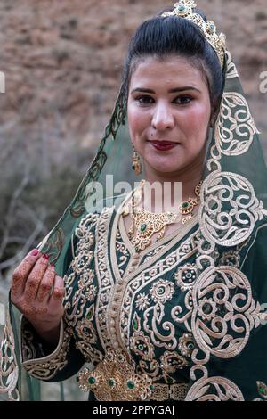 Porträt einer Braut in einem wunderschönen Kleid mit goldenen Motiven. Stockfoto