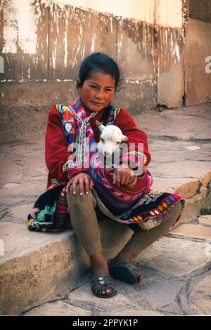 Junge Quechua-Frau mit Baby-Lamm auf dem zentralen Platz in Pisac, Peru Stockfoto