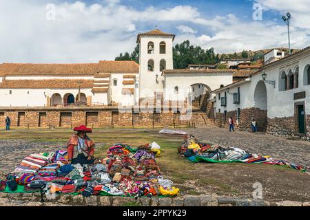 Kunsthandwerker, der einheimische Waren und Souvenirs verkauft, befindet sich am zentralen Platz von Chinchero Stockfoto