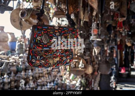 Handtasche mit Mustern verschiedener Farben in einem kleinen Souvenirladen in den Straßen von Ouarzazate. Stockfoto