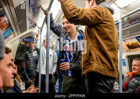 Brighton und Hove Albion Fußballfans reisen mit der London Underground auf dem Weg zum FA Cup Semi Final 2023 in London, Großbritannien. Stockfoto