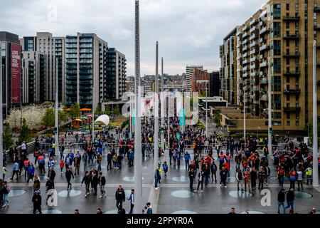 Fußballfans von Brighton und Hove Albion und Manchester United gehen auf dem Olympic Way zum Wembley Stadium, um das FA Cup Semi Final 2023 in London zu sehen. Stockfoto