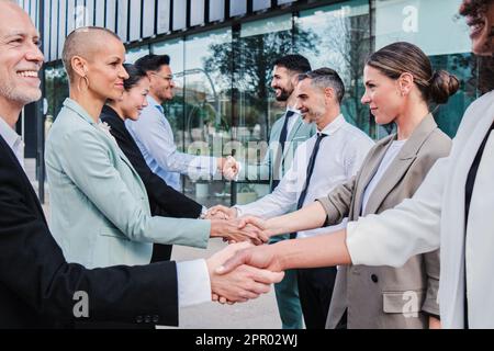 Gruppe von Geschäftsleuten, die sich im Arbeitsbereich mit einem Handschlag begrüßen. Geschäftsmänner und Geschäftsfrauen machen einen erfolgreichen Deal. Zusammenarbeit von Unternehmensteams und Partnerschaften. Startup-Mitarbeiter. Hochwertiges Foto Stockfoto