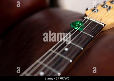 Gitarrenpick in Strings gehalten Stockfoto