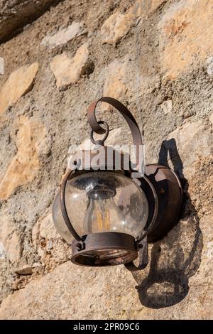 Rostige alte Lampe, antike Beleuchtung, Laterne an der Wand, rostige Vintage-Außenbeleuchtung, Straßenbeleuchtung, Straßenlampe, Lampenschatten aus Glas mit Kuppellaterne. Stockfoto