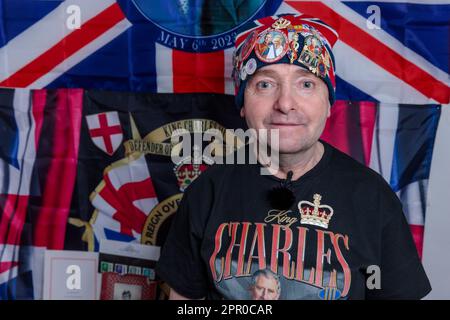 London, Großbritannien. 25. April 2023 Der königliche Superfan John Loughrey posiert vor der Krönung seiner Majestät am 6. Mai mit einigen seiner Erinnerungsstücke von König Karl III. John wurde von seiner Mutter inspiriert und ist seit seiner Kindheit ein königlicher Unterstützer und hat über viele Jahrzehnte eine große Sammlung von Erinnerungsstücken der britischen Königsfamilie gesammelt. Foto: Amanda Rose/Alamy Live News Stockfoto