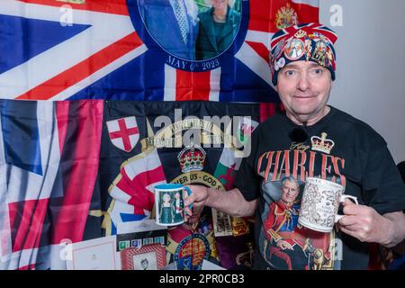 London, Großbritannien. 25. April 2023 Der königliche Superfan John Loughrey posiert vor der Krönung seiner Majestät am 6. Mai mit einigen seiner Erinnerungsstücke von König Karl III. John wurde von seiner Mutter inspiriert und ist seit seiner Kindheit ein königlicher Unterstützer und hat über viele Jahrzehnte eine große Sammlung von Erinnerungsstücken der britischen Königsfamilie gesammelt. Foto: Amanda Rose/Alamy Live News Stockfoto