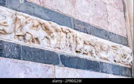 Marmordetails an der Fassade der Kathedrale von Messina oder des Duomo di Messina, Sizilien, Italien. Reliefs an der Wand, die menschliche Figuren und Traubenernte darstellen Stockfoto