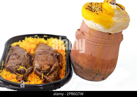 Hintergrund der ägyptischen Hamam-Tauben Mahshi gefüllte Squab mit Reis und Ein Töpfertopf mit Teig, Sesam und Lammschaft ist darin mit Bas bedeckt Stockfoto