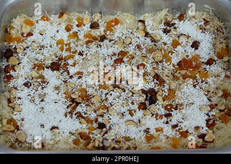 Ein traditionelles, nahöstliches Dessert Knafeh mit gesponnenem Gebäck namens Kataifi, getränkt in einem süßen, zuckerbasierten Sirup namens attar und geschichtet mit ha Stockfoto