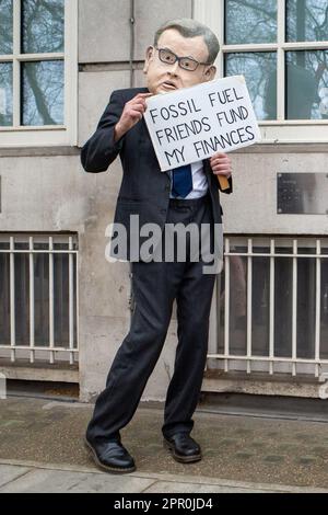 Demonstranten tragen eine Politikermaske und halten Plakat über Fossil Fuels beim Aussterben Rebellion Protest Weekend in der Nähe von Westminster, London, April 2023 Stockfoto