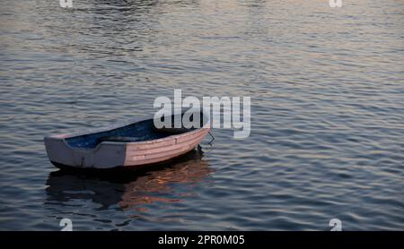 Kleines Boot am Strand bei Sonnenuntergang Stockfoto