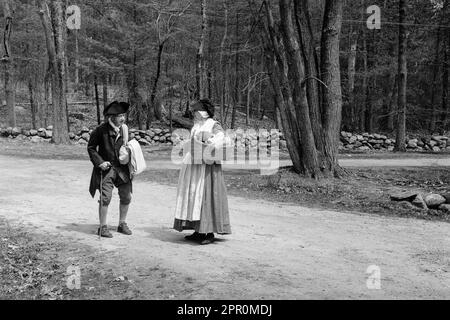 Zwei Schauspieler aus dem Revolutionskrieg, gekleidet in zeitgenössischer Kleidung, halten an, um sich auf dem Weg zu unterhalten, während sie Parkers Revenge im Minuteman National Historic nachspielen Stockfoto